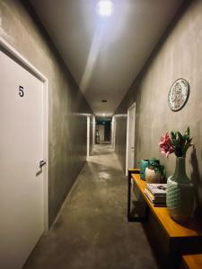 a hallway with a table and a vase with flowers on it at 518Hotel in San Josef +10 photos