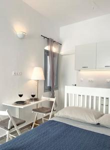 a bedroom with a bed and a table and chairs at Artemonas Beige Escape in Sifnos