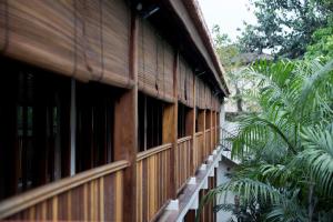 a building with wooden windows and some palm trees at Muntri Grove in George Town