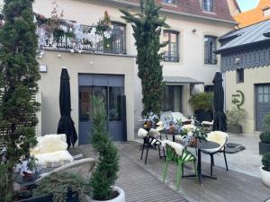 un patio con tavoli e sedie e un edificio di Hôtel Quatorze a Colmar