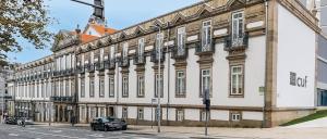 a large white building with a car parked in front of it at Fantasy Hostel Porto in Porto