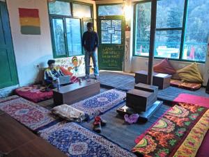 a man standing in a room with rugs on the floor at L'Ashrum Cafe & Inn in Tosh