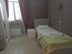 a small bedroom with a bed and a window at Keruen Deluxe in Taraz