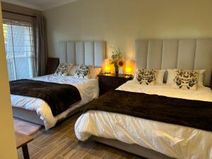 a bedroom with two beds and a window at Mont Vue Manor in Franschhoek
