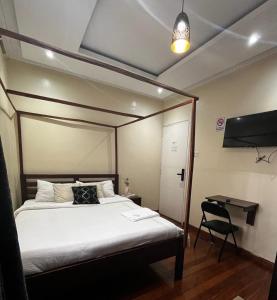 a bedroom with a bed and a desk and a lamp at KHAL HOST HUB in Nairobi