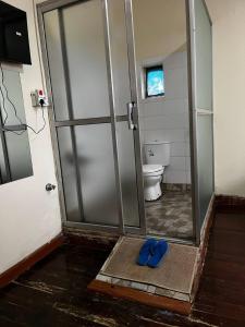 a bathroom with a shower with blue shoes on the floor at KHAL HOST HUB in Nairobi