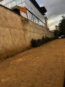 a concrete wall next to a building on a dirt road at KHAL HOST HUB in Nairobi