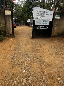 a sign sitting on the side of a dirt road at KHAL HOST HUB in Nairobi