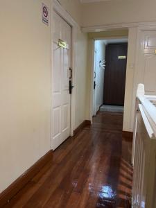 an empty hallway with a white door and wooden floors at KHAL HOST HUB in Nairobi