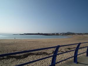 a view of a beach with a blue fence at The Beach Motel in Trearddur