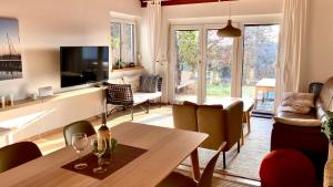 a living room with a table and a tv at Ferienhaus Seeblick in Breitenbrunn