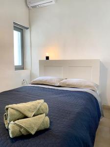 a bedroom with a bed with two towels on it at Artemonas White Escape in Sifnos