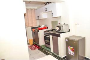 a small kitchen with a stove and a microwave at Pazuri in Ruiru