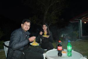 a man and a woman sitting at a table eating food at Dream Stay in Bhīm Tāl +26 photos