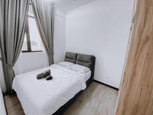 プトラジャヤにあるFamily Friendly Condo at Putrajayaのベッドルーム1室(靴を履いたベッド1台付)