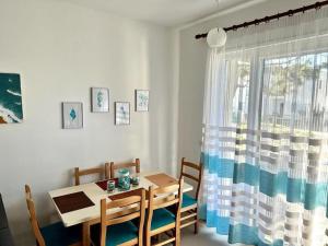 a dining room with a table and a window at Valamar Garden Apartment in Mullini i Danit