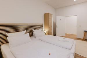 a white bed with white pillows in a room at Das MONTI - Comfort in Stendal