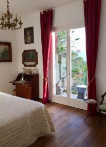 Un dormitorio con una cama y una puerta corrediza de vidrio. en Villa Lucherina, en Stresa