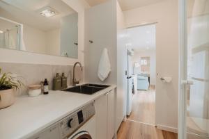 a white kitchen with a sink and a refrigerator at Tiny Home in Scottsdale in Scottsdale