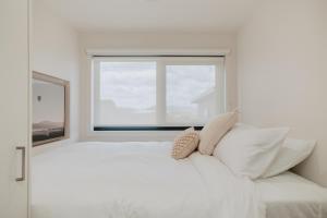 a white bedroom with a large white bed and a window at Tiny Home in Scottsdale in Scottsdale