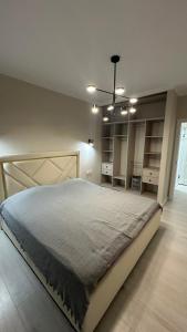 ein Schlafzimmer mit einem großen Bett in einem Zimmer in der Unterkunft 2-х комнатные апартаменты на Экспо in Astana