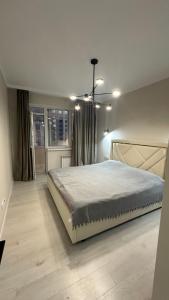 ein Schlafzimmer mit großem Bett und Fenster in der Unterkunft 2-х комнатные апартаменты на Экспо in Astana
