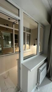 Zimmer mit 2 Fenstern und einem Schreibtisch mit einer Lampe in der Unterkunft 2-х комнатные апартаменты на Экспо in Astana