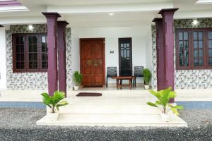 una veranda anteriore di una casa con porta in legno di Vagamon misty Hills Resort a Vagamon