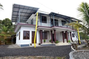 una casa bianca con un palo giallo davanti di Vagamon misty Hills Resort a Vagamon