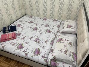 a bed with a white comforter and two pillows at Апартамент зал спальня кухня in Yunusobod