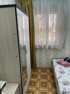 a small room with a bed and a window at Апартамент зал спальня кухня in Yunusobod +2 photos