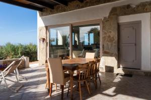 a wooden table and chairs on a patio at Villa Amea in Torre Dei Corsari