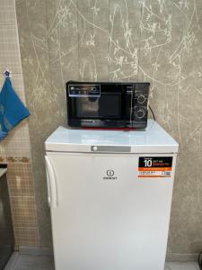 a microwave sitting on top of a refrigerator at Апартамент зал спальня кухня in Yunusobod