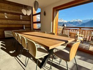 a table and chairs in a room with a mountain view at Chalet Petit Val in Combloux +22 photos