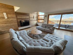 a living room with a couch and a tv at Chalet Petit Val in Combloux
