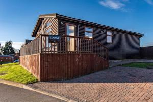 a house with a sign on the front of it at Countryside log cabin with HOT TUB! in Swarkeston