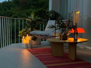 a balcony with a table and candles and a couch at Lighthouse Bingin - 360 view in Uluwatu