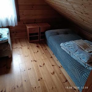 a bedroom with a bed and a wooden floor at Camping Bałtyk in Dźwirzyno