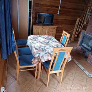a dining room with a table and chairs and a television at Camping Bałtyk in Dźwirzyno
