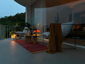 a room with a table and a bed on a balcony at Lighthouse Bingin - 360 view in Uluwatu +60 photos