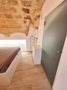 a bedroom with a bed and a wooden floor at Vico Farinella 12 Small Room in Polignano a Mare