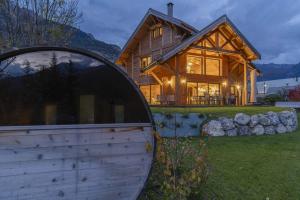 a large wooden house with a large round window at Chalet Ecrin des Vignes in Les Vigneaux