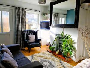 ein Wohnzimmer mit einer Couch und einem Spiegel in der Unterkunft 'Shakespeare Cottage' - Free Parking near Salisbury Railway Station & Walk to City in Salisbury