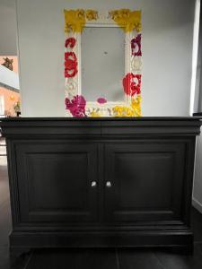 a black cabinet with a mirror on top of it at Chez Marie in Rosheim +41 photos