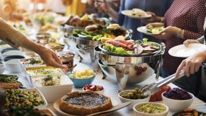 a table full of plates of food with people reaching for food at Porto Sokhna Majestic in Ain Sokhna