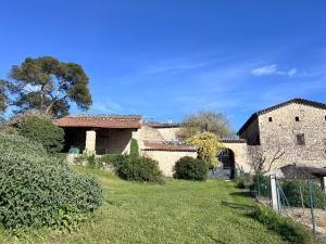 ein altes Steingebäude mit einem Hof und einem Haus in der Unterkunft Le Mas Du Gentilhomme Chambre Glycine in Orthoux-Sérignac-et-Quilhan