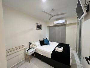 a bedroom with a bed and a television in it at CBD Esplanade Location - Quiet & Comfortable in Darwin