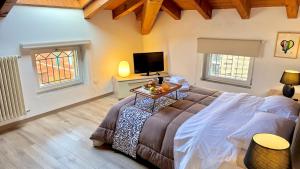 ein Schlafzimmer mit einem Bett und einem Fernseher und zwei Fenstern in der Unterkunft AxelParkComo in Como