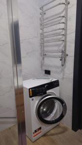 - un lave-linge et un sèche-linge dans un coin de la salle de bains dans l'établissement VIP апартаменти біля озера, à Rivne