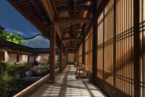 福州福州三坊七巷安民半舍文化酒店Fuzhou Sanfang Qixiang Anmin Banshe Cultural Hotel的享有带顶棚走道的建筑外部景色